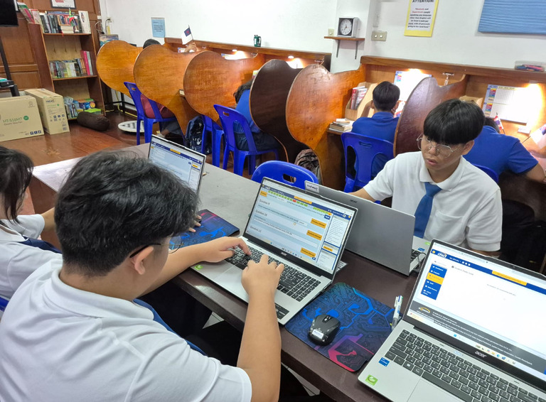 Schüler arbeiten gemeinsam an Laptops im Computerzentrum und lernen digitale Grundlagen