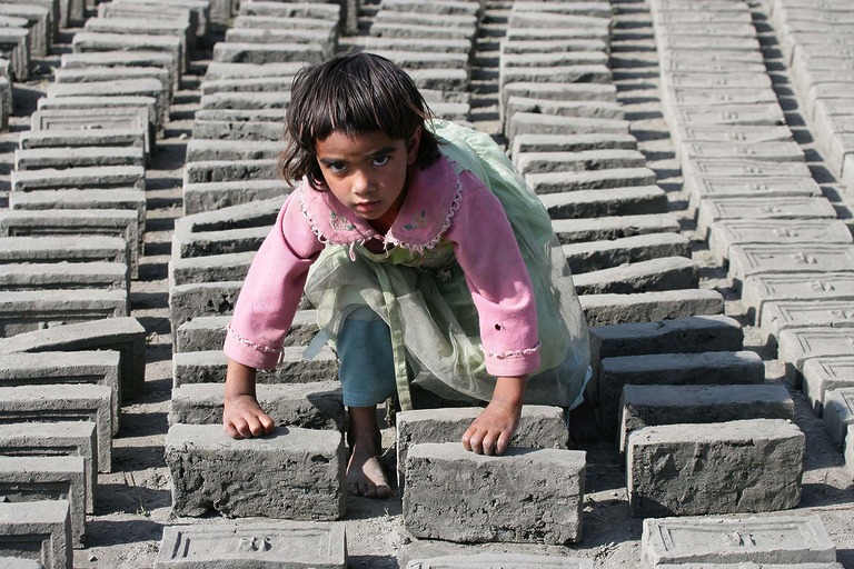 Sechs jahre altes Mädchen drehen Ziegel -Ziegelfabrik