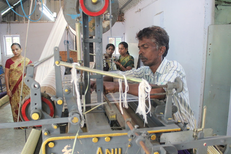 Mann arbeitet an einer Webmaschine in einer Werkstatt in Tamil Nadu – Förderung lokaler Handwerksbetriebe